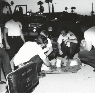 Paramedics helping a man. - May 1977
