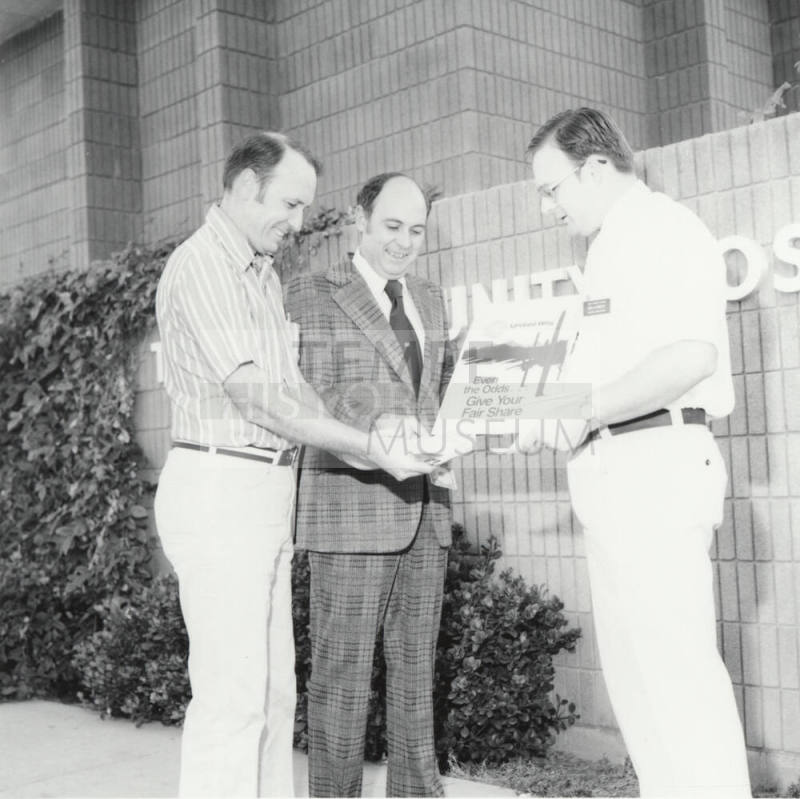 Three Unidentified Men Share Money