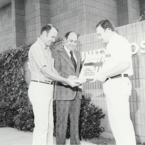 Three Unidentified Men Share Money