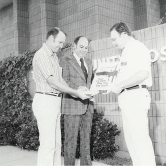 Three Unidentified Men Share Money