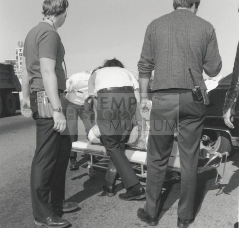 Paramedics loading traffic victim onto gurney.