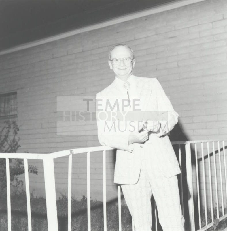 Bill Hanna Stands Outside Holding Watch