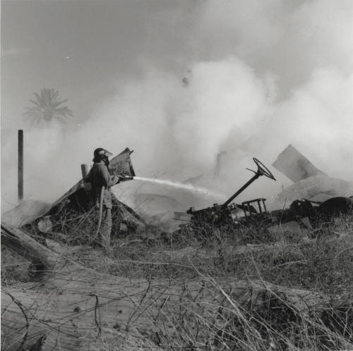 Firefighter Uses Fire Hose On Buildings Smoking Remains