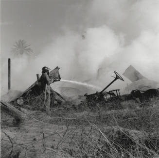 Firefighter Uses Fire Hose On Buildings Smoking Remains