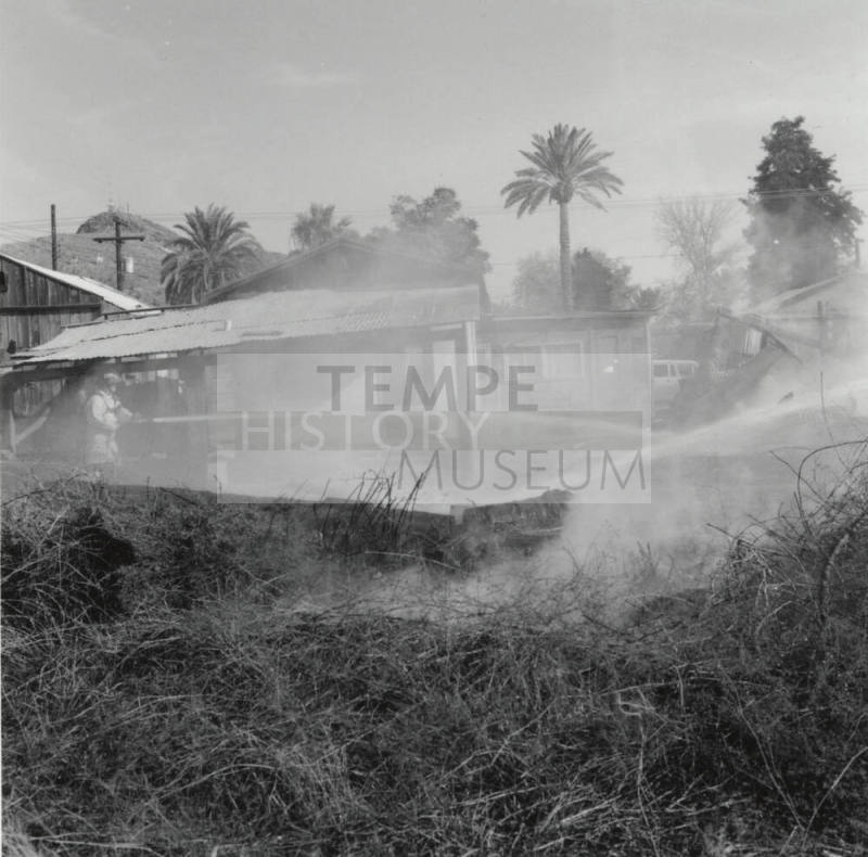 Firefighters Spray Water On Burnt Houses