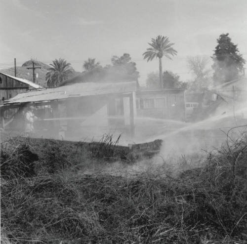 Firefighters Spray Water On Burnt Houses