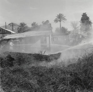 Firefighters Spray Water On Burnt Houses