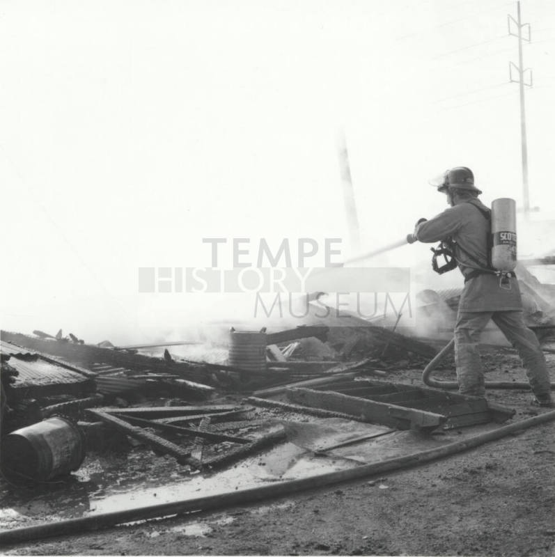 Firefighter Sprays Water On Smouldering Building