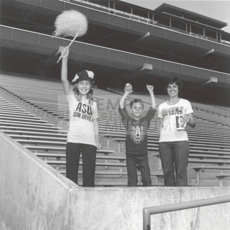 Boy, Girl And Woman Stand in Sun Devil Stadium Bleachers