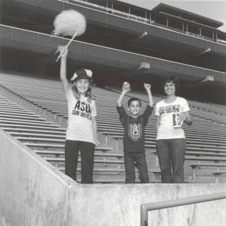 Boy, Girl And Woman Stand in Sun Devil Stadium Bleachers