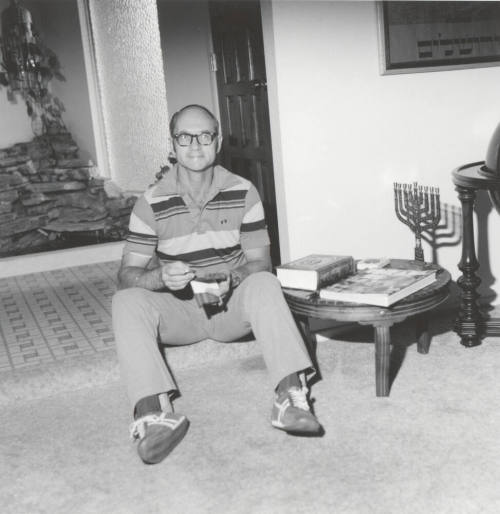 Man sitting on floor inside of home