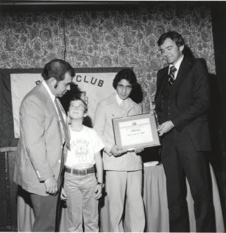 Boy receiving honors with a certificate