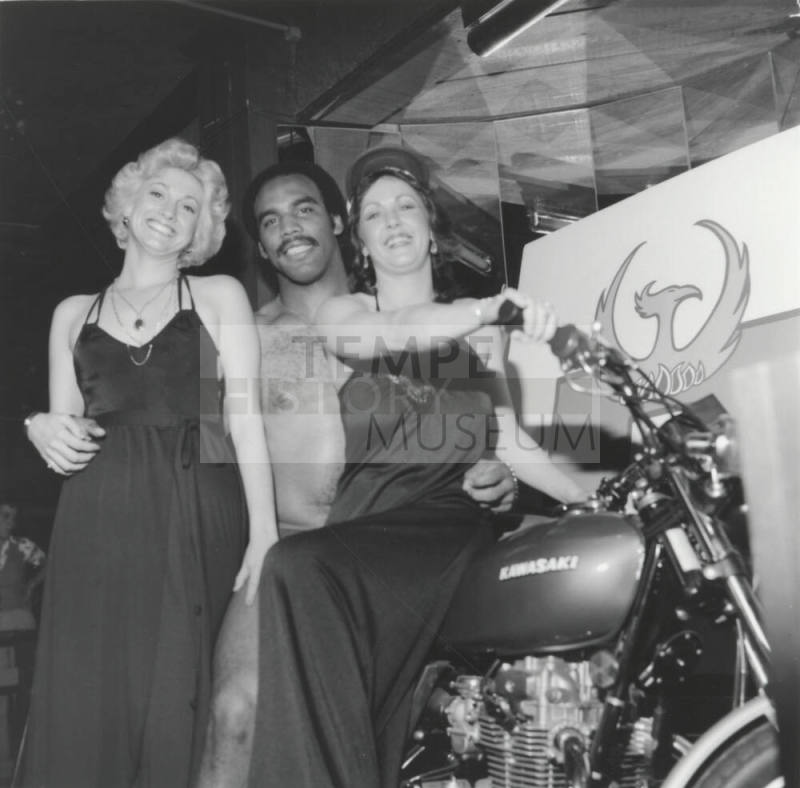 Two women, a man, and a motorcycle