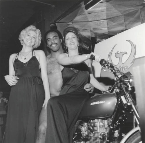 Two women, a man, and a motorcycle