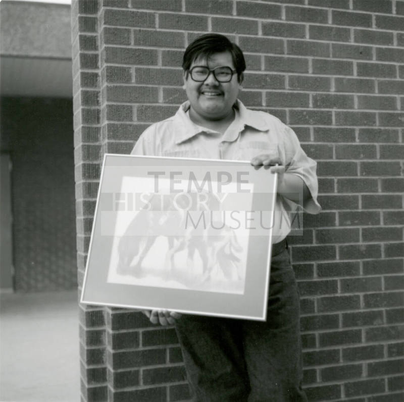 Man with framed artwork, February 1978