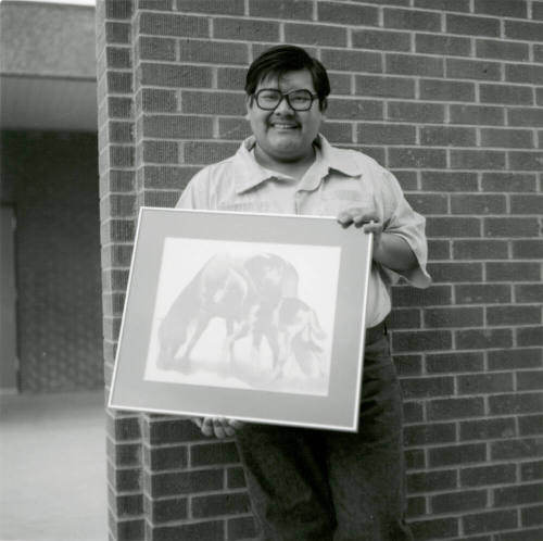 Man with framed artwork, February 1978