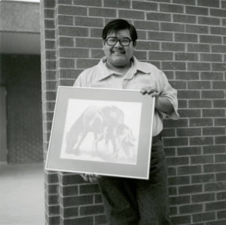 Man with framed artwork, February 1978