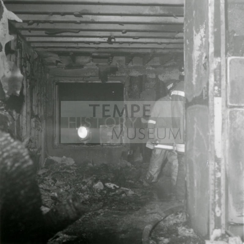 Firemen in burned-out structure, February 1978
