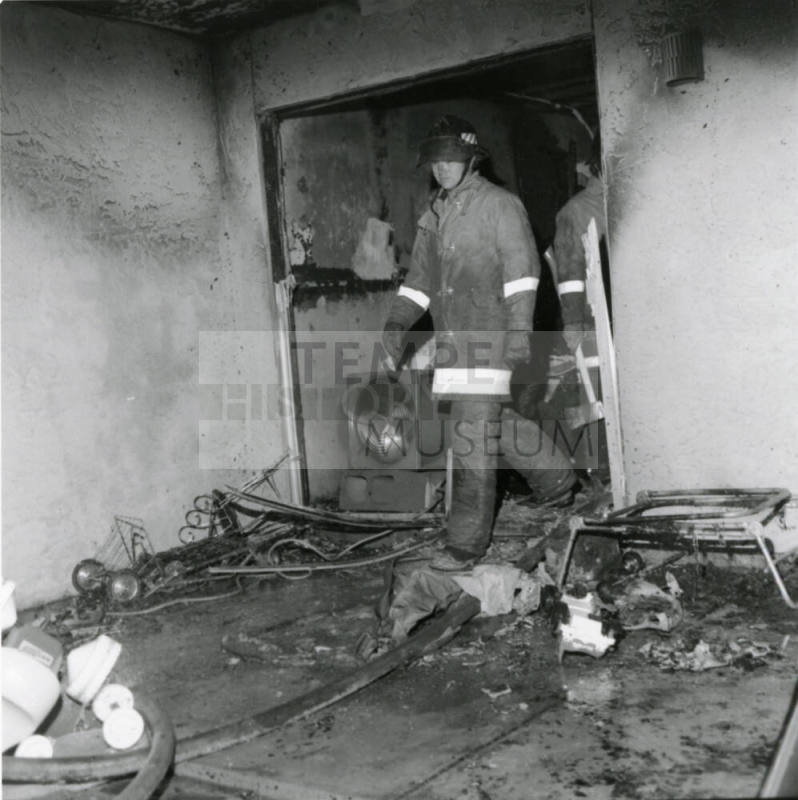 Firemen in a burned-out structure, February 1978