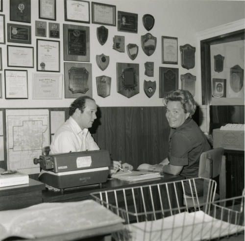 Man and woman sit at a desk  - June 1978