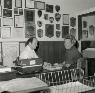 Man and woman sit at a desk  - June 1978