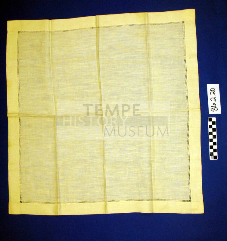 Eggshell white linen table scarf with eyelet trim by hems.