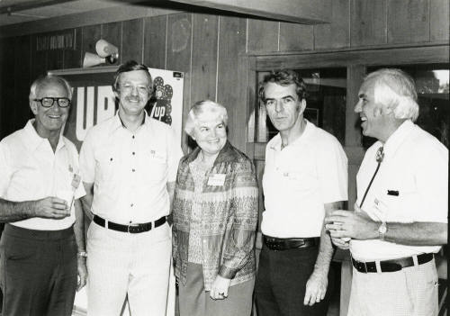 Four men and a woman at a soda dispenser.