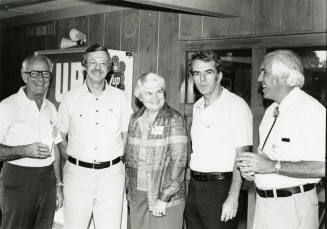Four men and a woman at a soda dispenser.