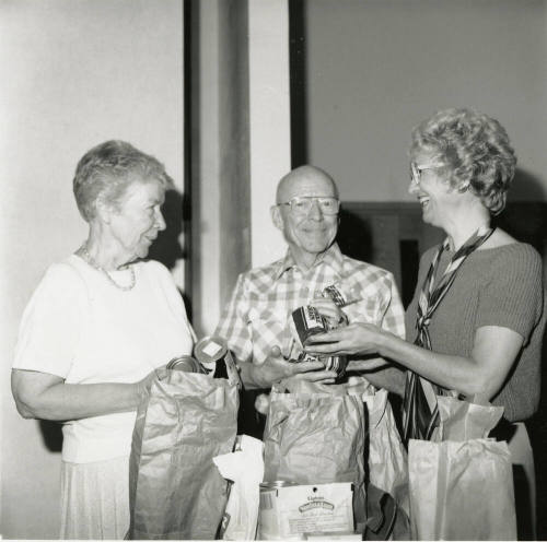 Three unidentified people with bags of groceries