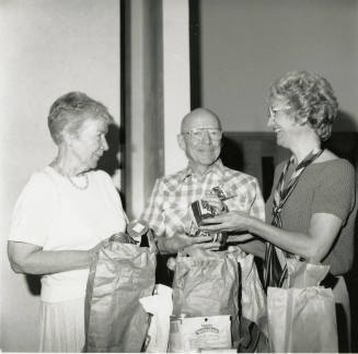 Three unidentified people with bags of groceries