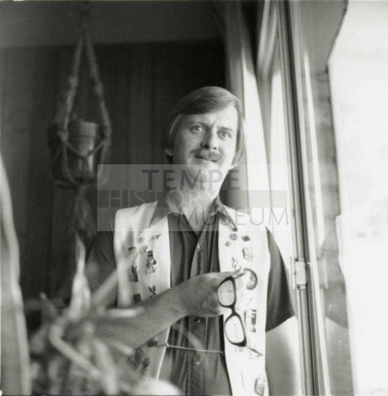 Unidentified man wearing an open vest with pins and sewn patches
