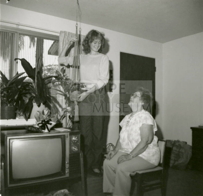 Unidentified standing lady and unidentified sitting lady