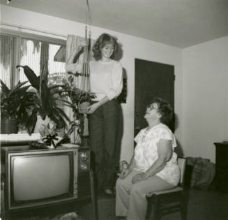 Unidentified standing lady and unidentified sitting lady