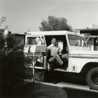 Unidentified postman puts mail in a mailbox