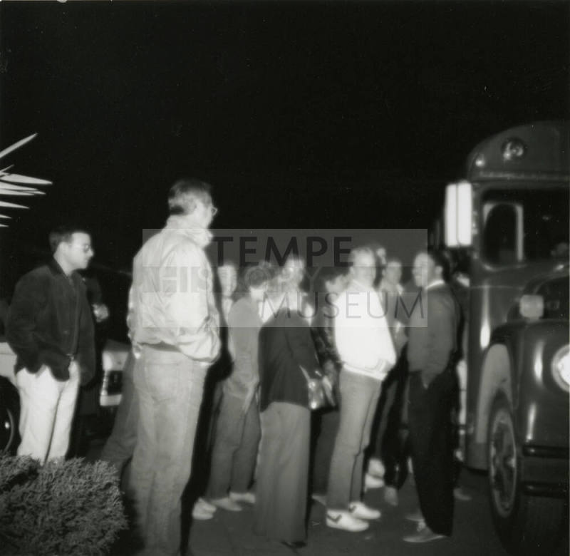 Unknown group of men standing beside a bus