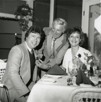 Young woman and two men, one being given a sheriff's badge