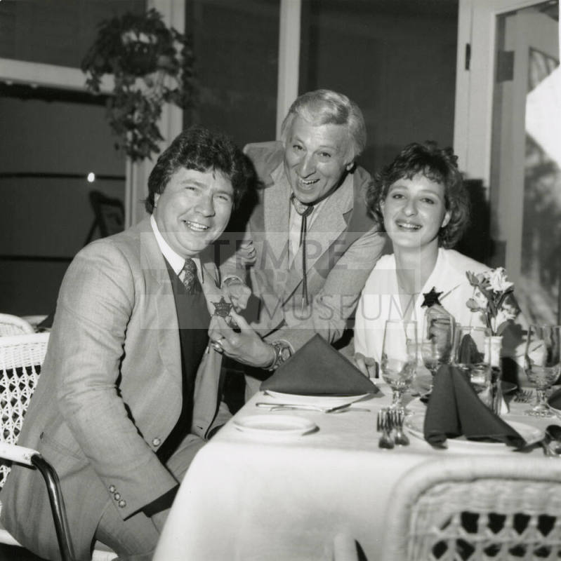 Young woman and two men, one being given a sheriff's badge