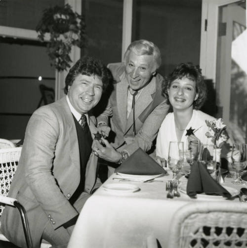 Young woman and two men, one being given a sheriff's badge
