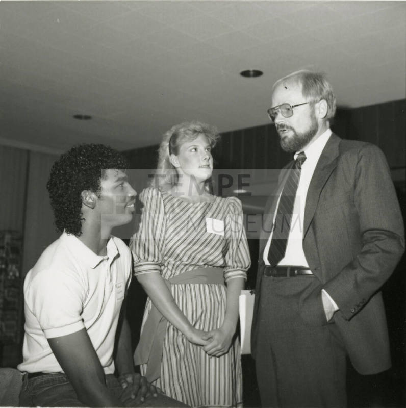 Older Man Speaking with Two Unidentified Teenagers