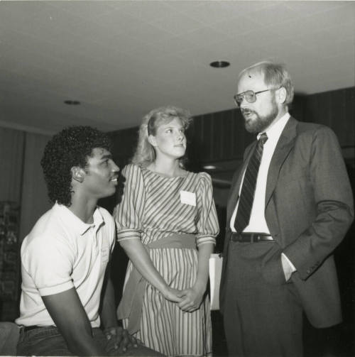 Older Man Speaking with Two Unidentified Teenagers