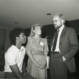 Older Man Speaking with Two Unidentified Teenagers