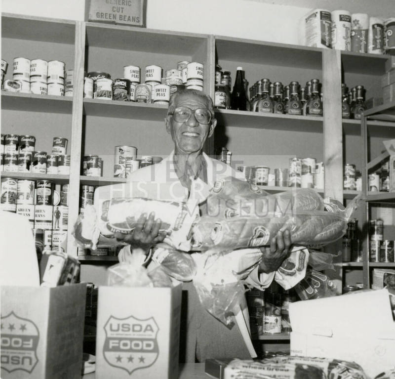 Man holds loaves of bread in a grocery store