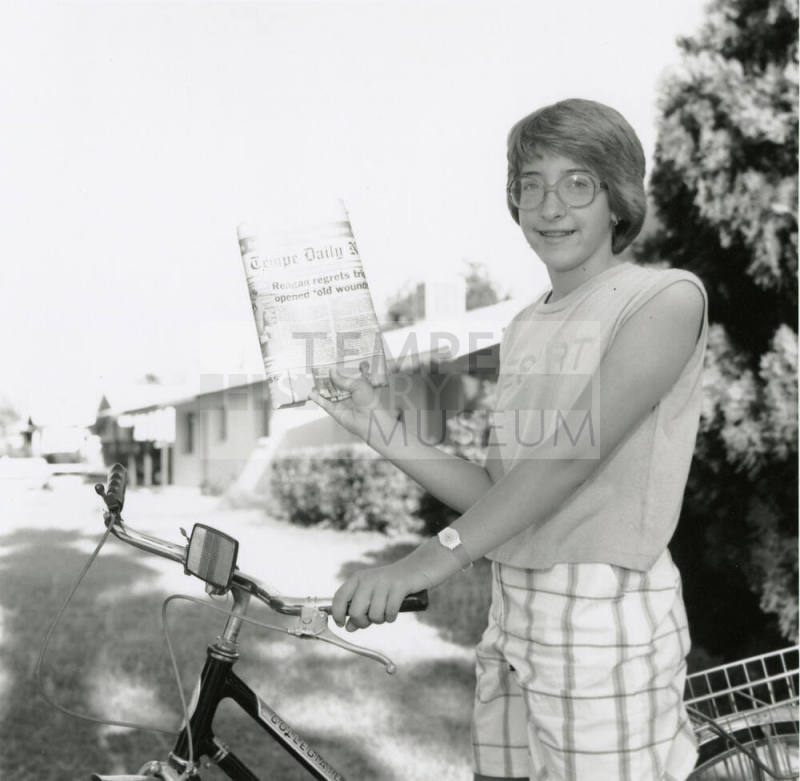Carrier hangs up her paper bag, from Tempe Daily News, May 11, 1985
