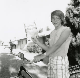 Carrier hangs up her paper bag, from Tempe Daily News, May 11, 1985