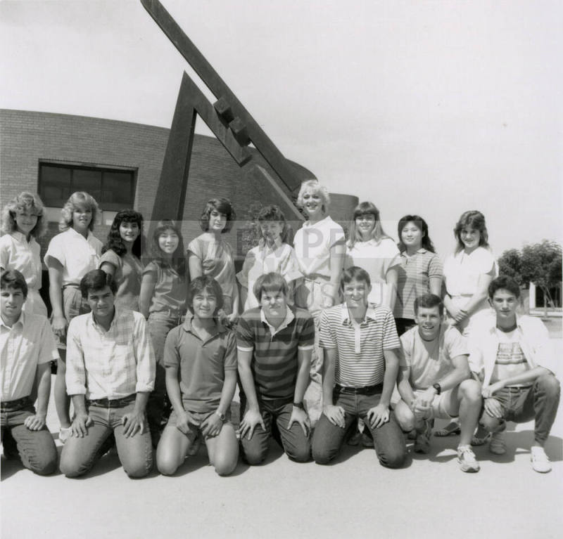 Group of youths in front of brick building with metal sculpture