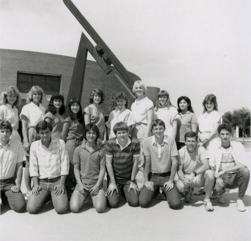 Group of youths in front of brick building with metal sculpture