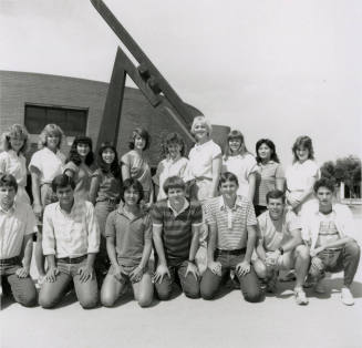 Group of youths in front of brick building with metal sculpture