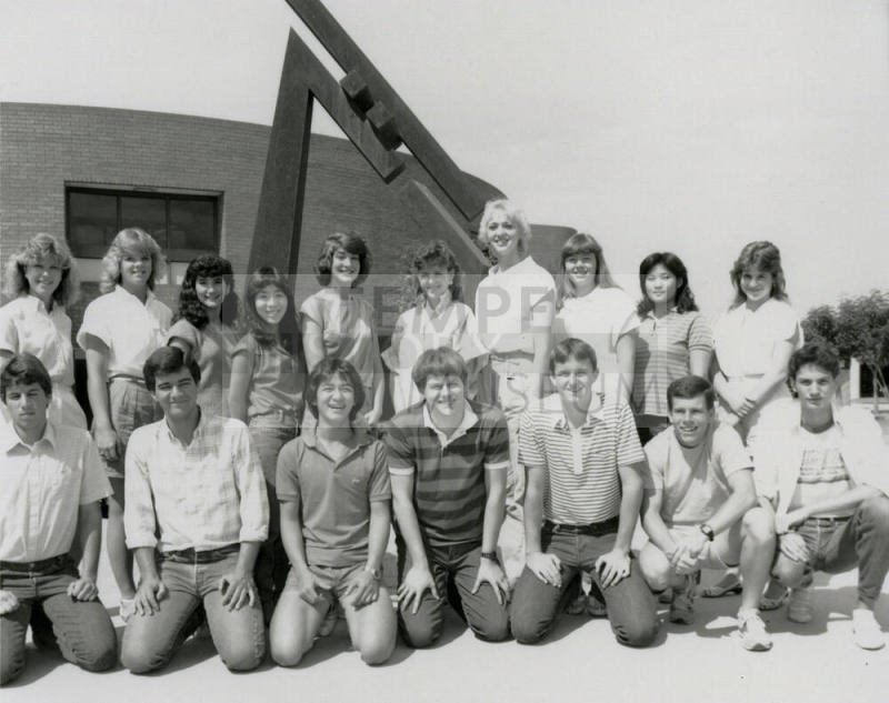 Group of youths in front of brick building with metal sculpture