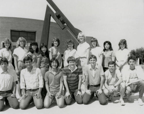 Group of youths in front of brick building with metal sculpture