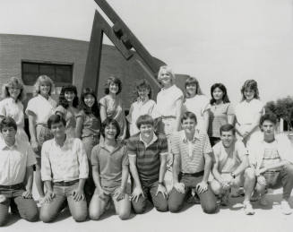 Group of youths in front of brick building with metal sculpture